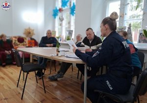 policjantka siedząca przy stole z seniorami