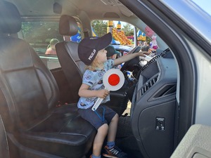 chłopczyk w radiowozie z tarczą do zatrzymywania pojazdów